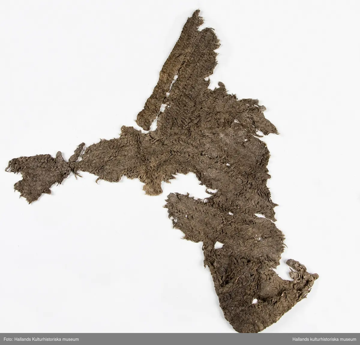 Arkeologiskt föremål. Fragment av en socka i nålbindning. 