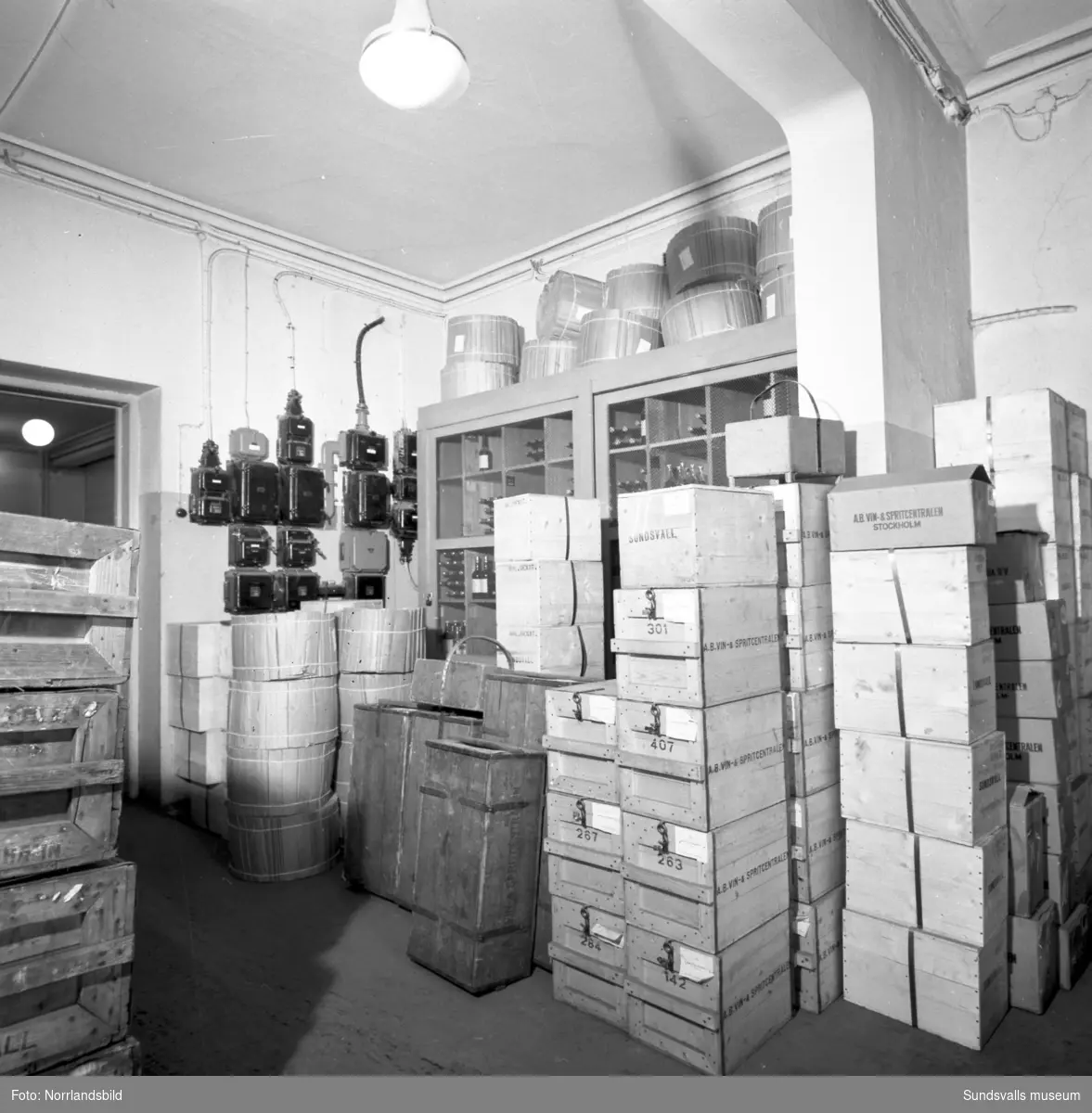 En stor serie bilder från verksamheten i Vin & Spritcentralens gamla lokaler vid Trädgårdsgatan-Bankgatan, allt från diskning av flaskor till lagring, tappning, kontorsarbete och reparationer.