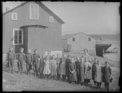 18 skolebarn i samme alder (7-8 år) og lærerinne fotografert