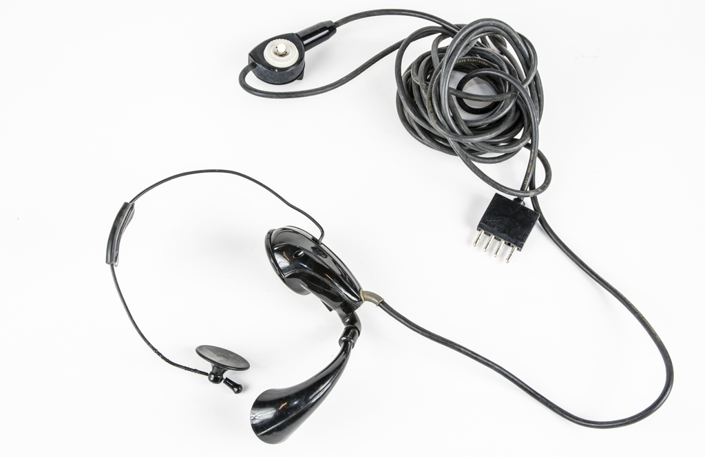 Hörtelefon, headset. Enklare hörtelefon att fästa på huvudet med hörsnäcka och tallur monterat på vänstersida.