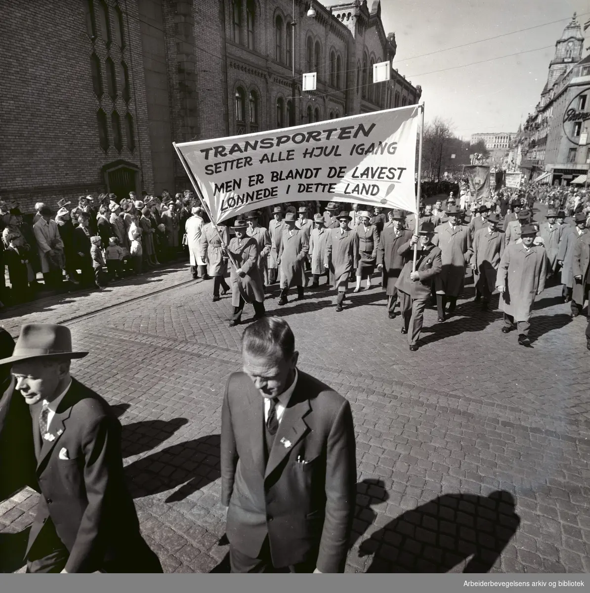 1. mai 1960 i Oslo.Karl Johans gate..Demonstrasjonstoget..Parole: Transporten setter alle hjul igang men er blant de lavest lønnede i dette land!.
