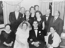 1 brudepar og 10 ander personer i pene klær.