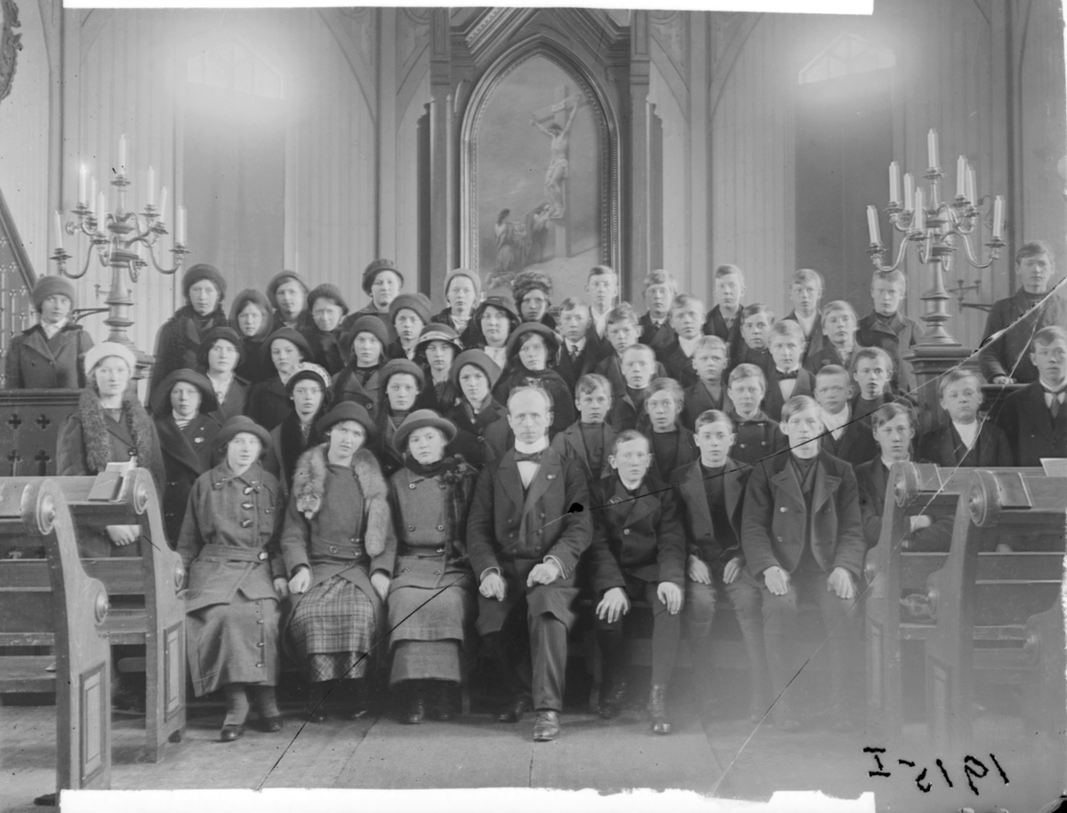 Konfirmanter, Vardø 1915. Bildet er tatt inne i kirka. Midt i første rekke presten Johan Oskar Grasmo