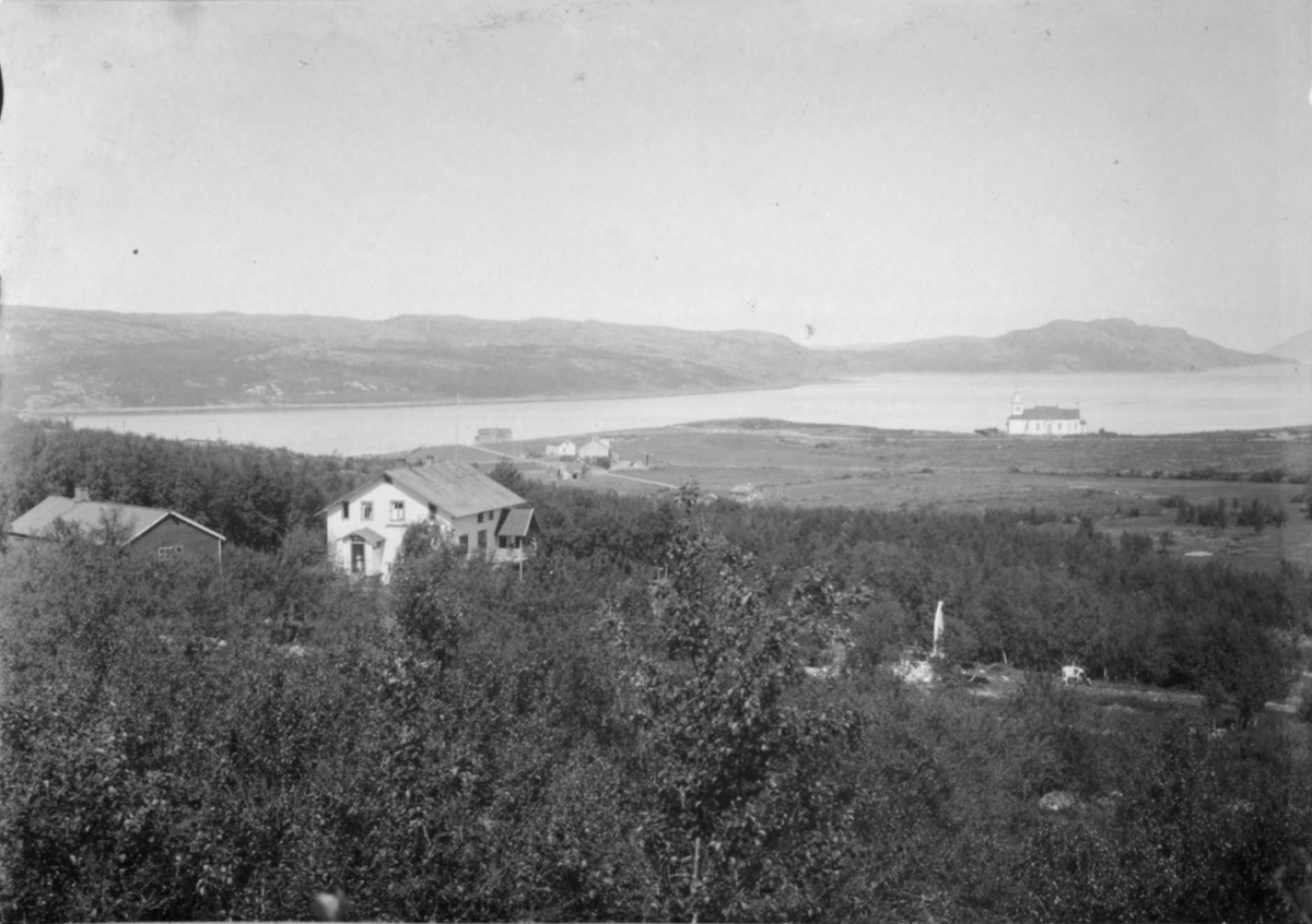 Kirkenes fotografert fra høyden rett over doktogården Solheim. Nærmest kamera til venstre doktorgården. Kirkenes kirke ligger til høyre i bildet
