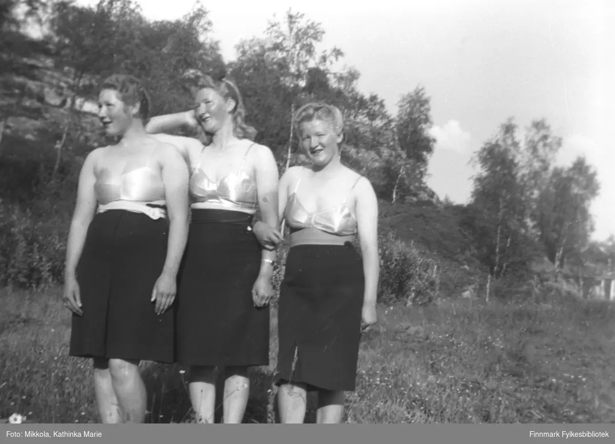 Søstrene Kari, Marine og Gudrun Mikkola på Badejordet på Mikkelsnes. Alle tre har badedrakter under skjørtet
