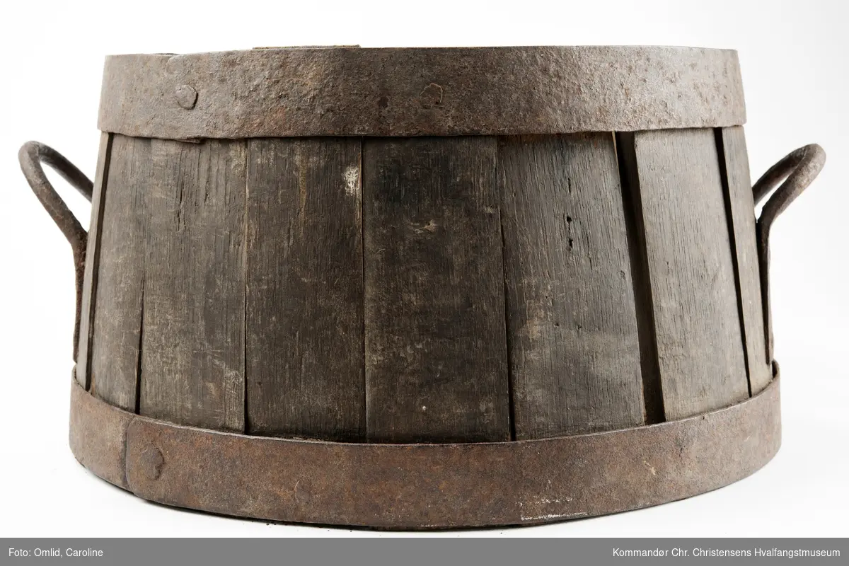 Form: Sylindrisk, konisk oppad. Tønneformet målekar for korn. Lagget med hanker av jern og jernbånd.