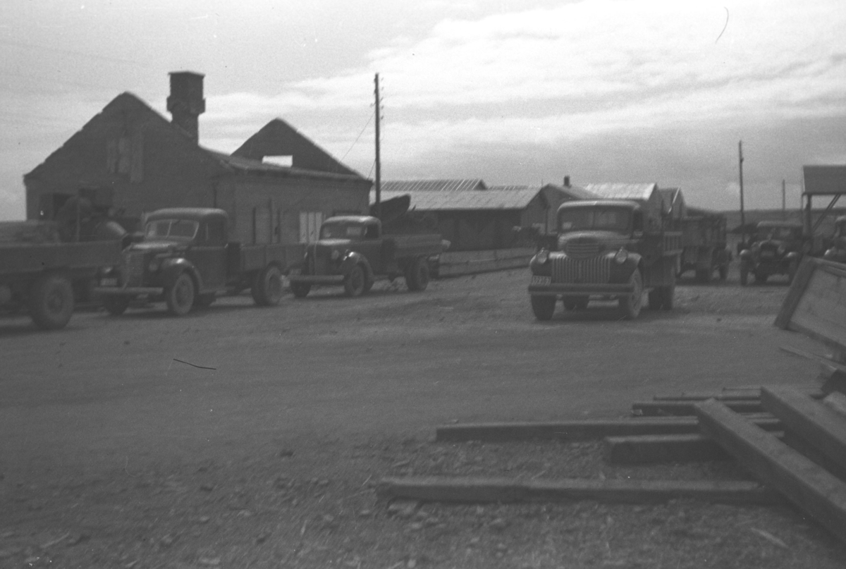 Polarbil-bygget i Vadsø med en del mindre lastebiler parkert utenfor. Noen av bilene kan være, bakerst til venstre, en tysk eller fransk Ford V8, 1941 mod. Til høyre for midten en tysk eller fransk Ford 1946-47 mod(litt eldre hvis det var en militær utg). Til høyre på bildet, sannsynligvis en Ford AA 1930 mod. Avbildet var standard størrelse, 1.5-2 tonns lasteevne, fordi veiene ikke tålte mer.