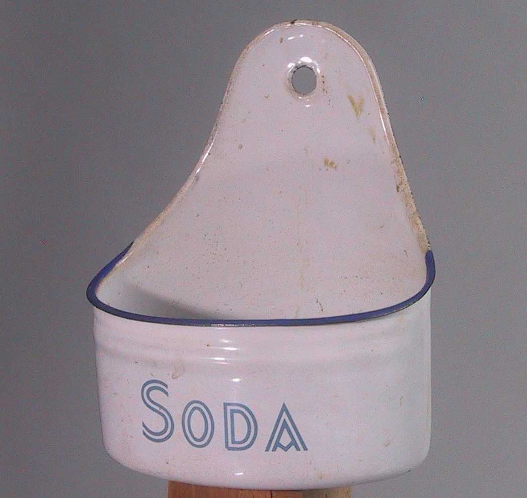 Sodaskål, kjøkkenbruk.  Emaljert, hvit med blå kant og tekst:  Soda. 

Hull for opphengning på vegg.