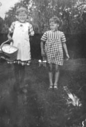 Jenter som har plukket egg. Jenta med hvitt forkle over kjol