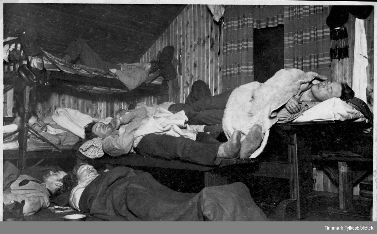 Garnisonen i Sør-Varanger. Gruppebilde fotografert inne i brakka. Soldater slapper av i sengene