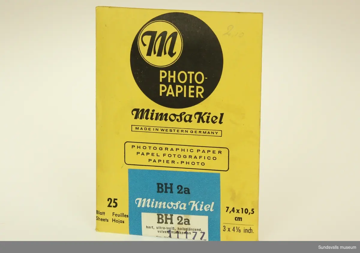 Gult kuvert innehållande 25 stycken fotopapper med vit och blå etikett.