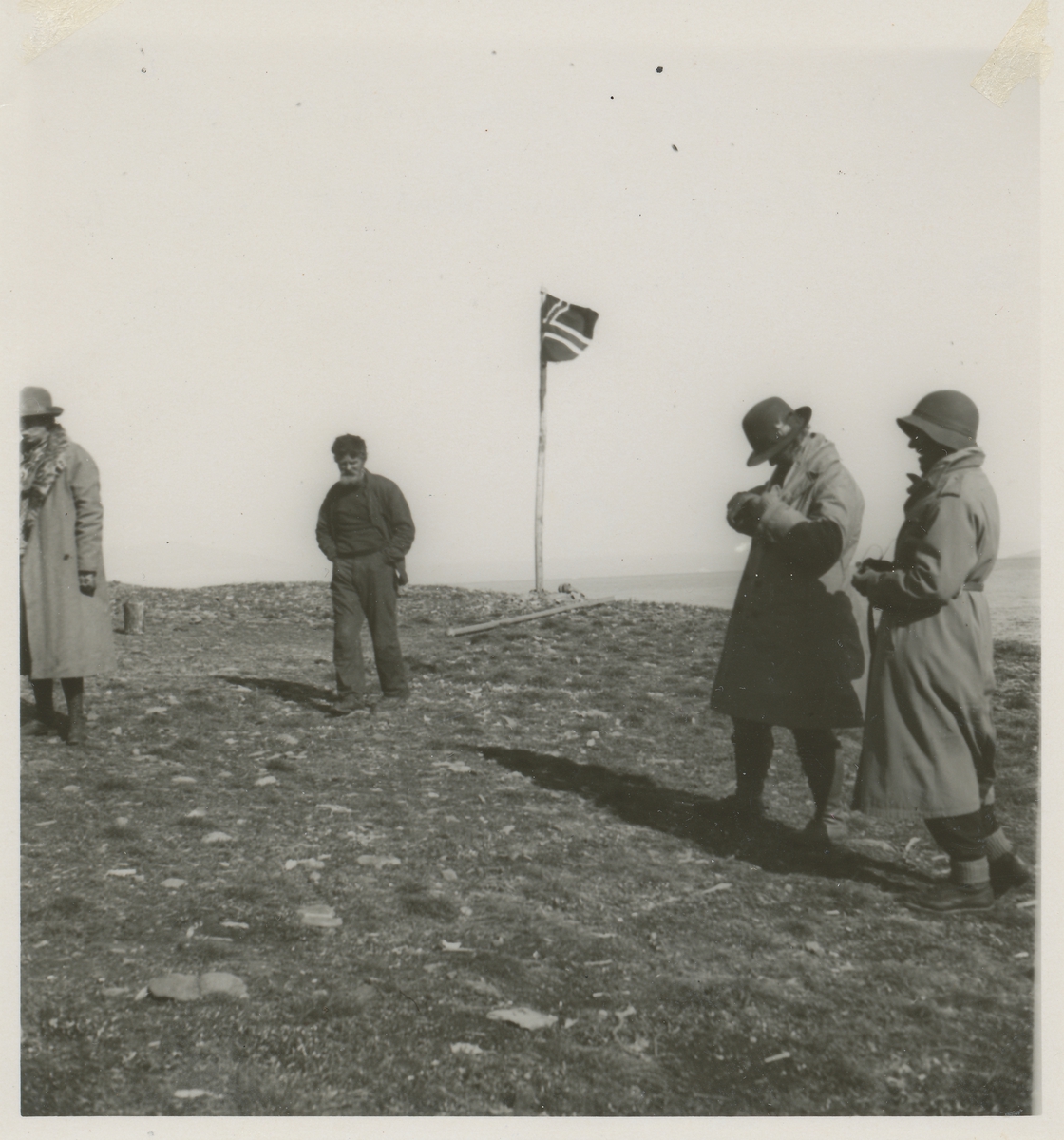 Det norske flagg heist ved Kap Humboldt. Skjeldrup og tre andre menn med i motivet.