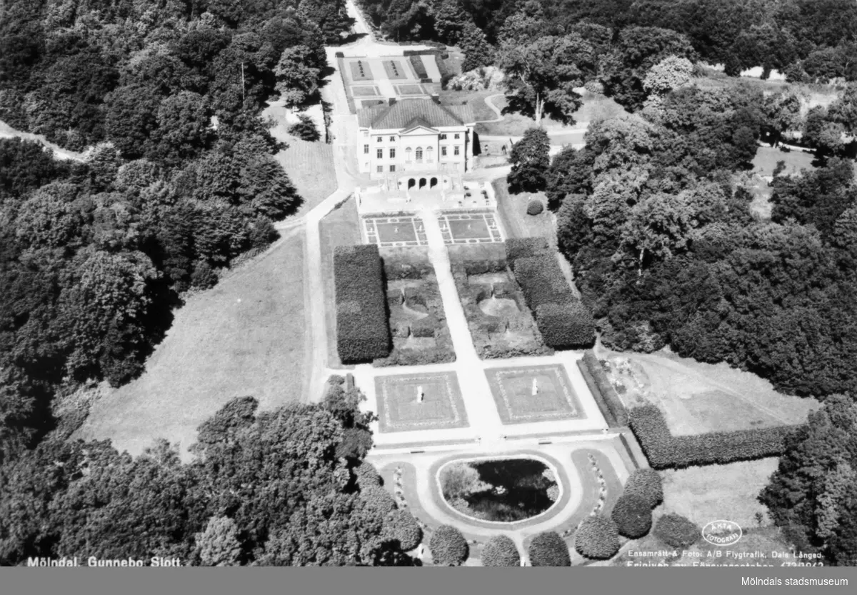 Flygfoto från söder på Gunnebo slott. Man ser trädgårdsdammen, södra trädgården, huvudbyggnaden och norra trädgården i bakgrunden. 1960-70-tal.