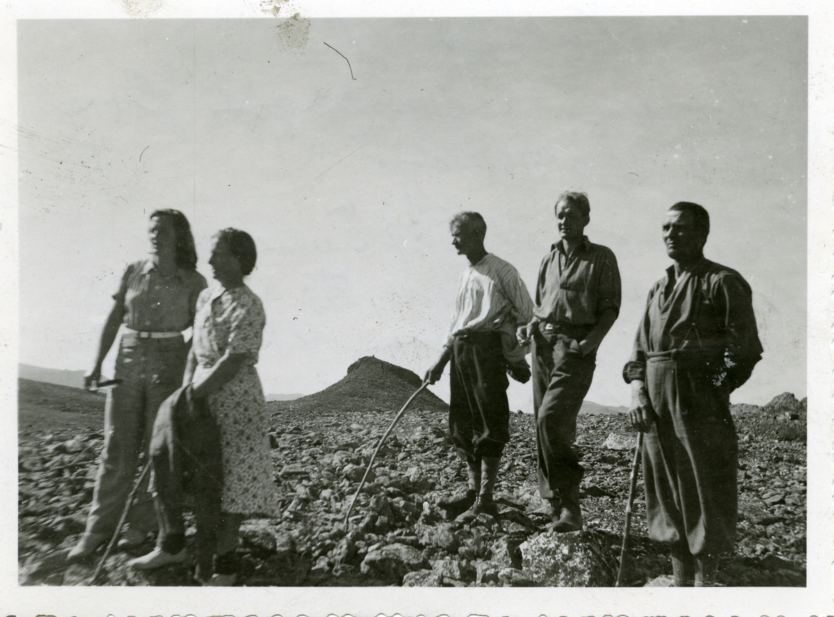 To kvinner og tre menn avbildet foran en fjellknaus i Valdres.