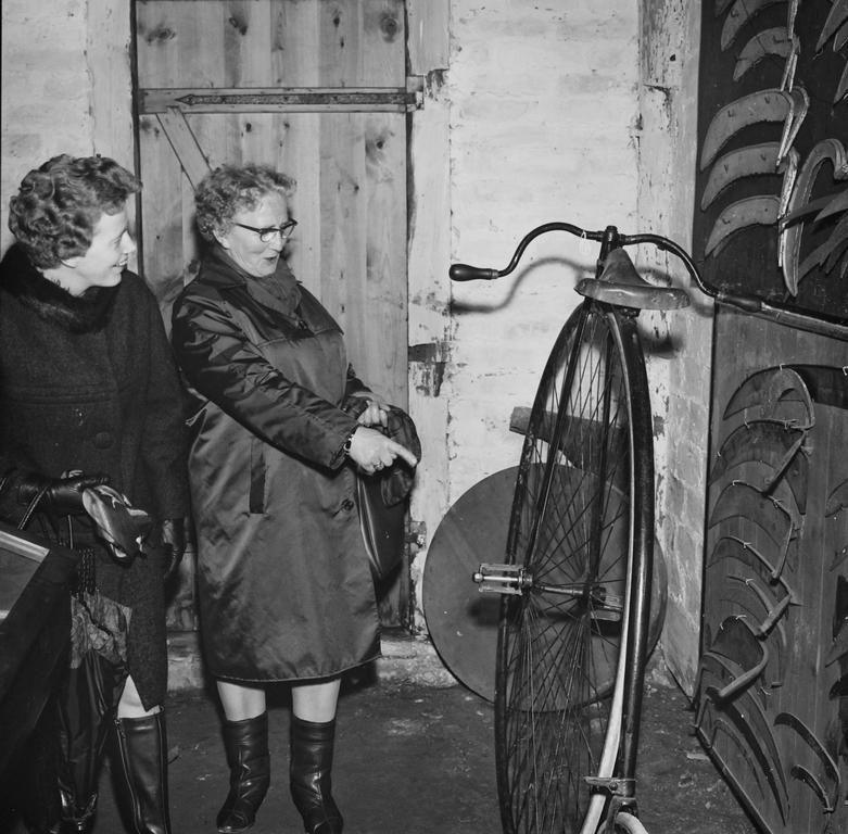 To kvinner fra Husmorlaget betrakter sykkelen, som OG Kverneland har laget på bedriftsmuseet til Kvernelands Fabrikk AS