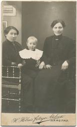 Studioportrett av to kvinner og en gutt.