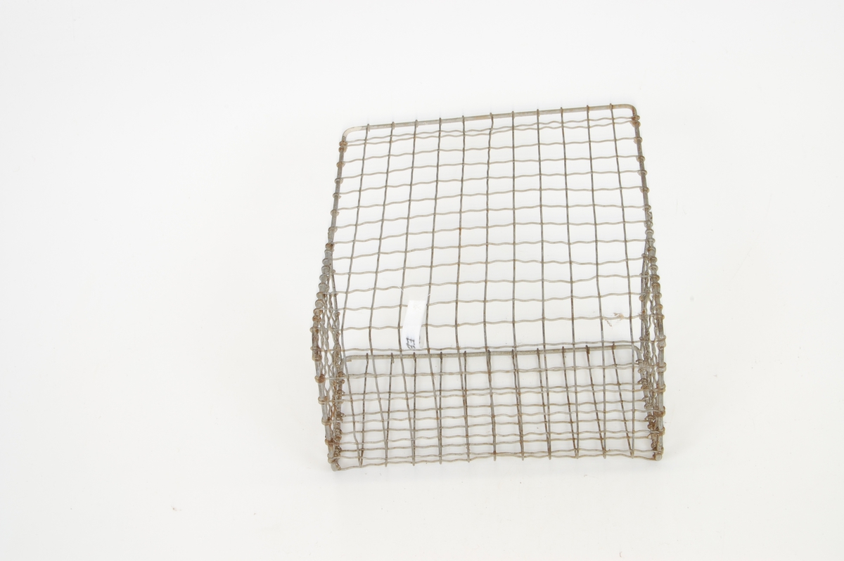 Form: firkantet kurv, ene veggen dobbelt så høy som de andre, ståltrådnetting med kvadratiske ruter
