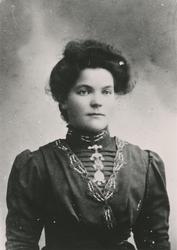 Portrett av en kvinne med finklær og søljer.