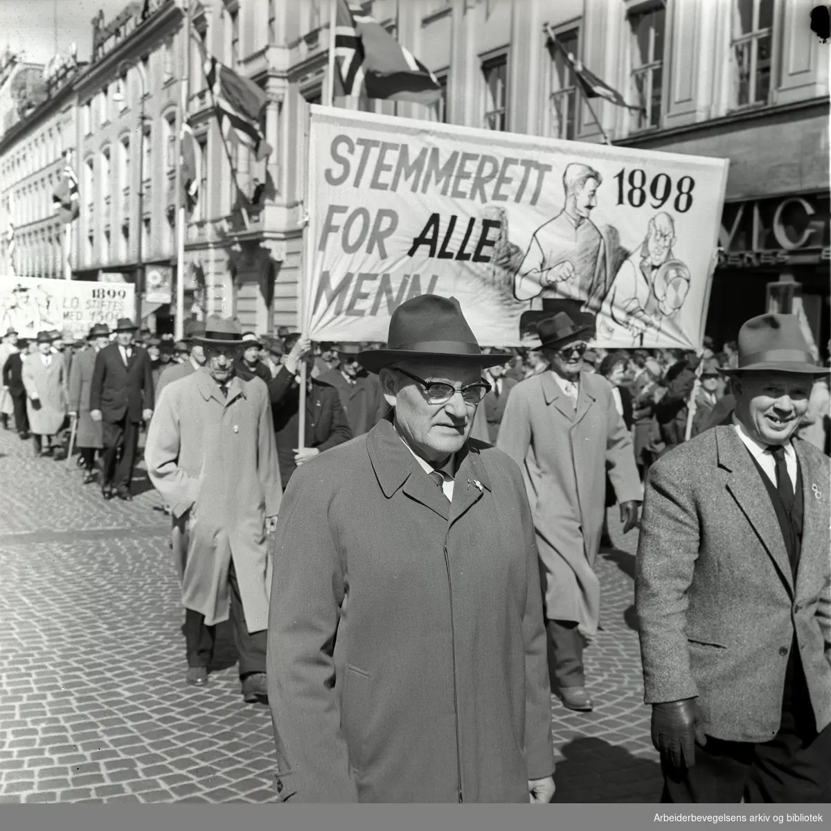 1. mai 1962 i Oslo.Demonstrasjonstoget i Karl Johans gate.Parole: Stemmerett for alle menn 1898