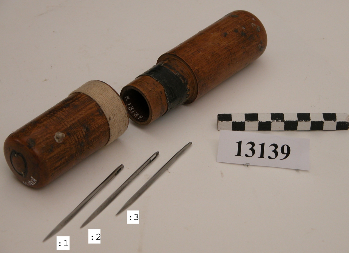 Nål för segelsömmare av stål. Nålarna förvaras i cylindriskt fodral av trä med märkning: S. H. (Sten Hansson)