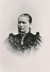 Portrett av en kvinne med finklær og sølje.