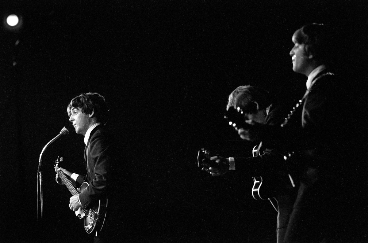 Konsert med det engelske bandet The Beatles i K.B. Hallen i København. På scenen John Lennon nærmest, George Harrison og Paul McCartney.