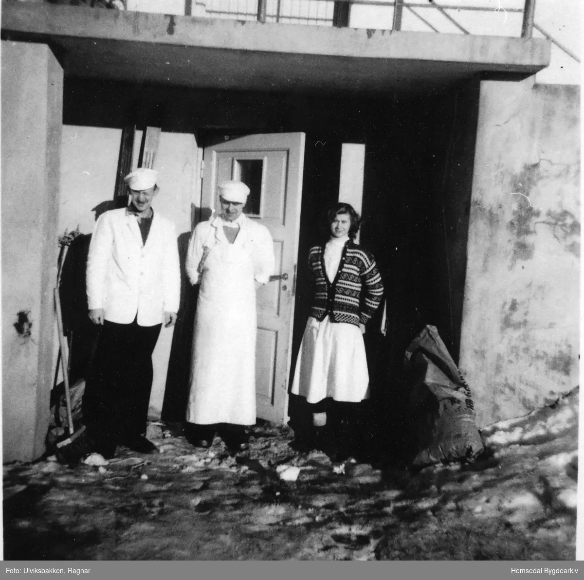 Tilsette ved døra til pølsemakeriet i Hemsedal Kjøttforretning i 1958.
Frå venstre: Arvid Bækken, Knut Anderdal og Randi Gulliksden