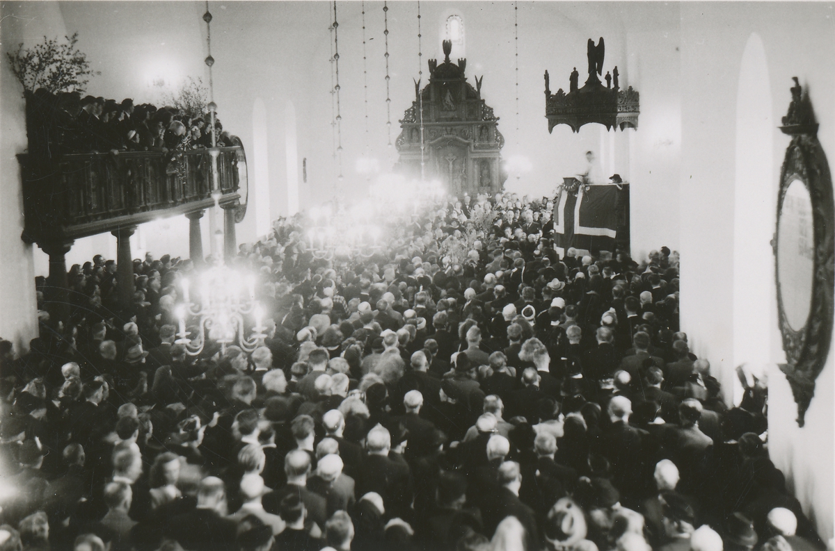 Motiv av forsamlingen under en gudsteneste i Borgund kirke, mai 1945. (Flaggdekt preikestol)