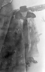 Mann ute en vinterdag, har stor kjørepels? på seg.