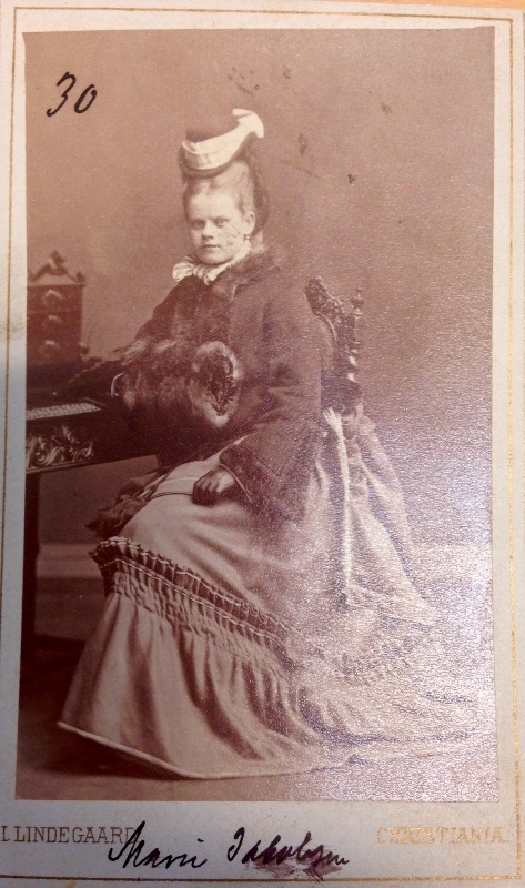Fire bilder i visittkortstørrelse. Portretter av kvinner i klær fra 1800-tallet.
Det er notert navn og /eller nummer på alle fotografiene.