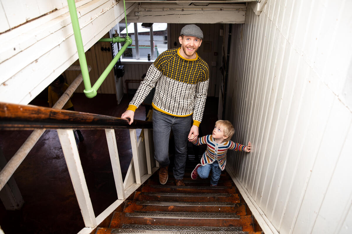 Mann og barn går opp trapp i fabrikklokale (Foto/Photo)