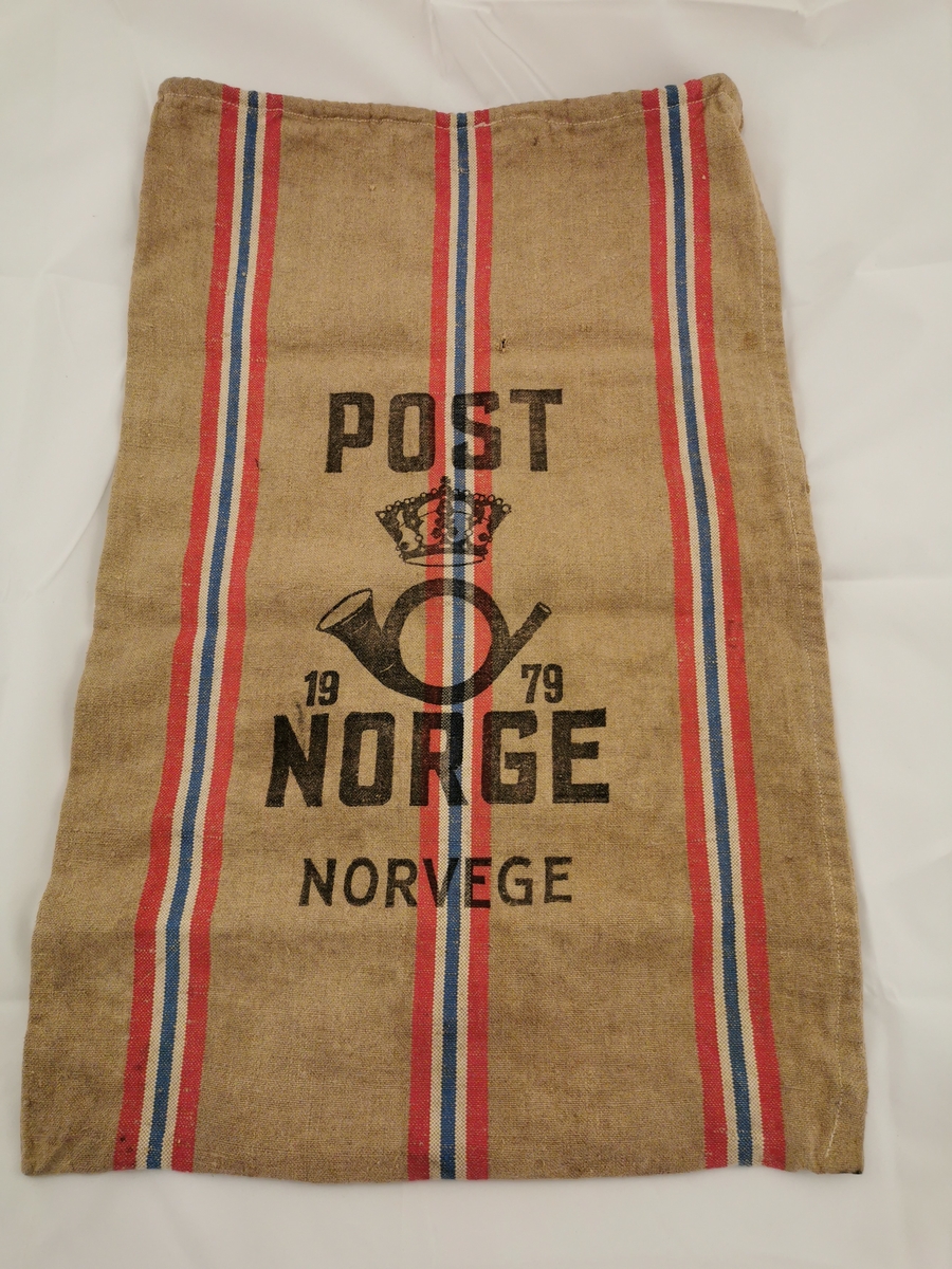 Rektangulær striesekk med tre striper med de norske farger. Søm i begge sider og med en løpegang i toppen med ei snor innvendig. Det er små hull på begge sider.