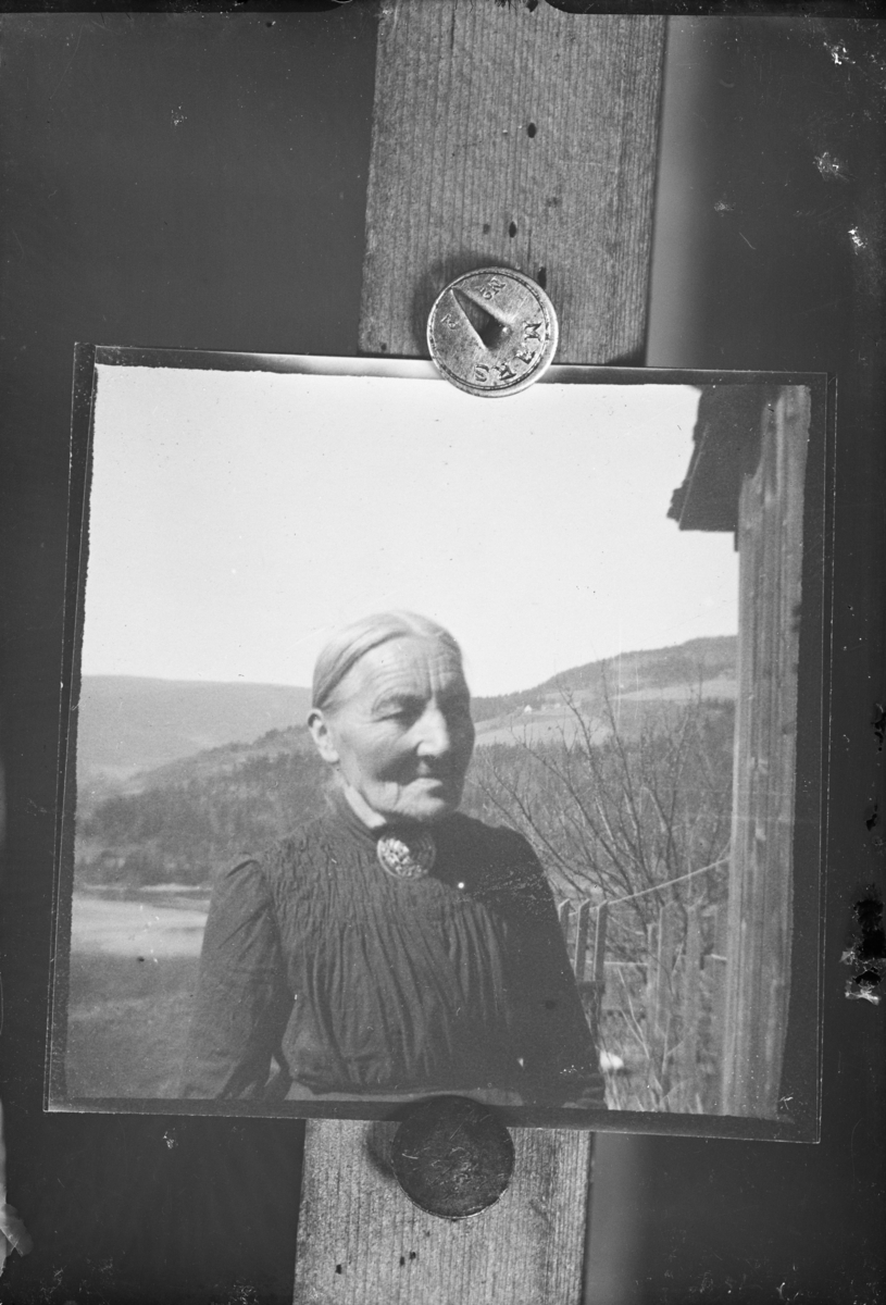 Reprofotografi av en eldre kvinne. Stor brosje i halsen, og muligens Jørstadhøgda i bakgrunnen.