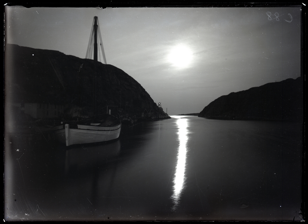 Juli 1924. Månskensfotografi med fiskebåt och farledsfyr, den södra smala delen av sundet Havstenssund.