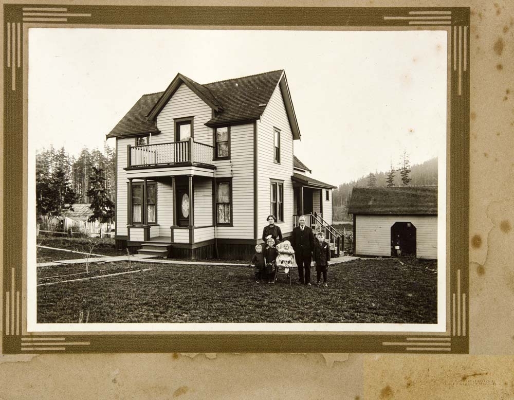 USA, Washington. Familie, to voksne og fire barn foran bolighus (navn ukjent).