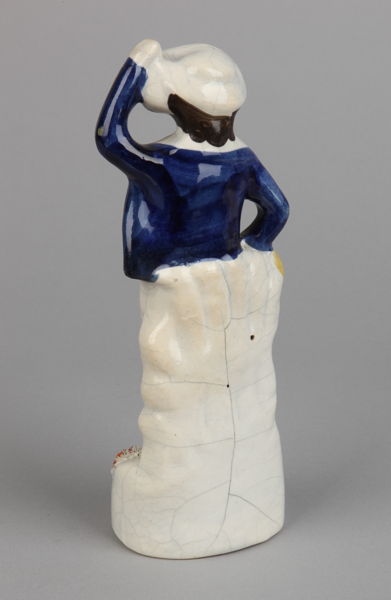 Porselensfigur av en sjømann med hatt og øltønne