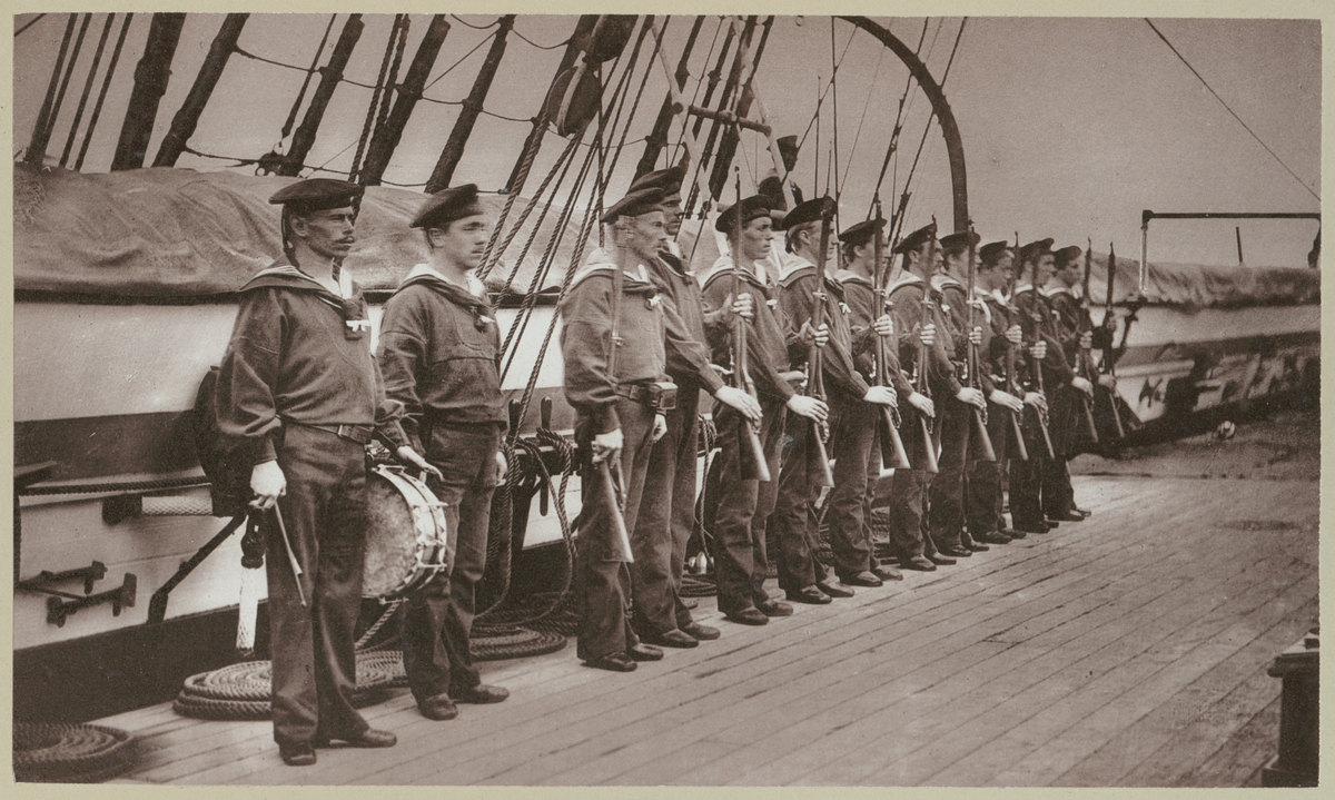 Bilden förställer tyska sjömän ombord på korvetten Stosch som har tagit uppställning för att hälsa en stabsofficerare ombord.
