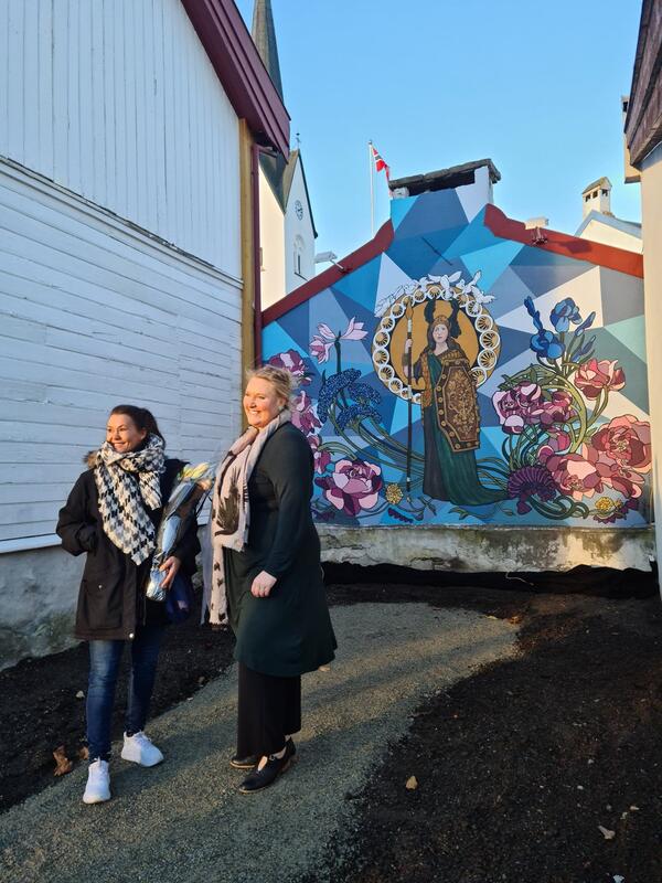 Kunstner Anna Louise Andersen og museumsleder Annika Grundt foran veggmaleriet av Kirsten Flagstad