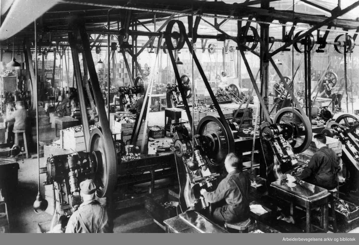 Interiør fra stanseverkstedet ved Nobø fabrikker A/S i Trondheim i 1930-årene. Jern- og Metallarbeiderforeningen i byen hadde et svare strev med å få arbeiderne ved denne bedriften organisert. Bedriften brukte mye ufaglært arbeidskraft, unge gutter som ble sagt opp før de var 19 år, så bedriften slapp å betale dem minstelønn som spesialarbeidere. I årene 1932 - 1936 var det stadig tvister og hele seks streiker ved bedriften.