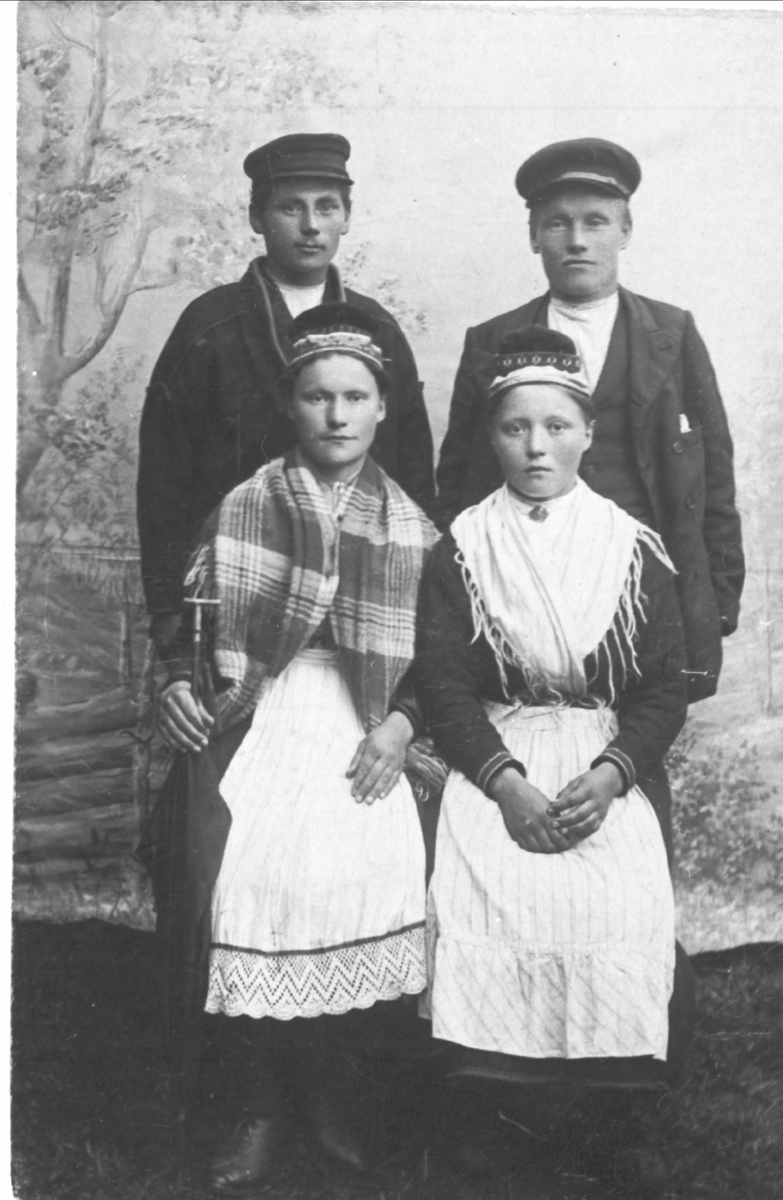 Gruppeportrett av fire personer, tre med samisk drakt.