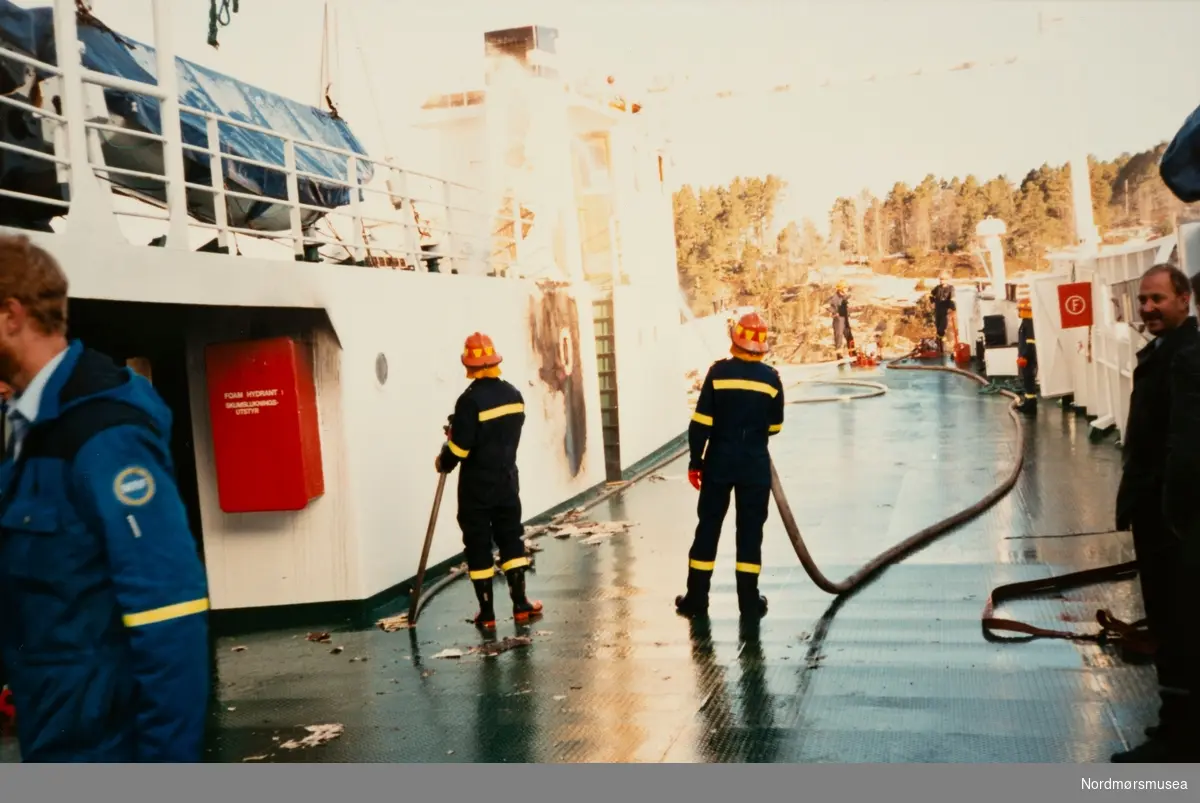 Foto fra et fergedekk. Trolig fotografert i forbindelse med en brann ombord. Ukjent hvor og når. Bildet er fra avisa Tidens Krav sitt arkiv i tidsrommet 1970-1994. Nå i Nordmøre museums fotosamling.