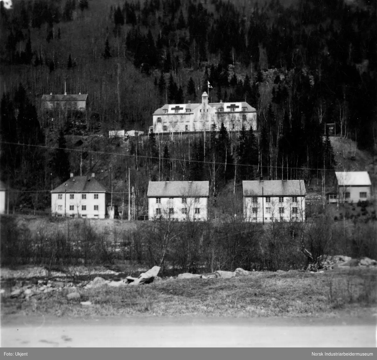 Rjukan sykehus med kors på taket for å hindre bombing under krigen. O-type bolighus sees i forgrunnen. Lasarettet til venstre for sykehuset.