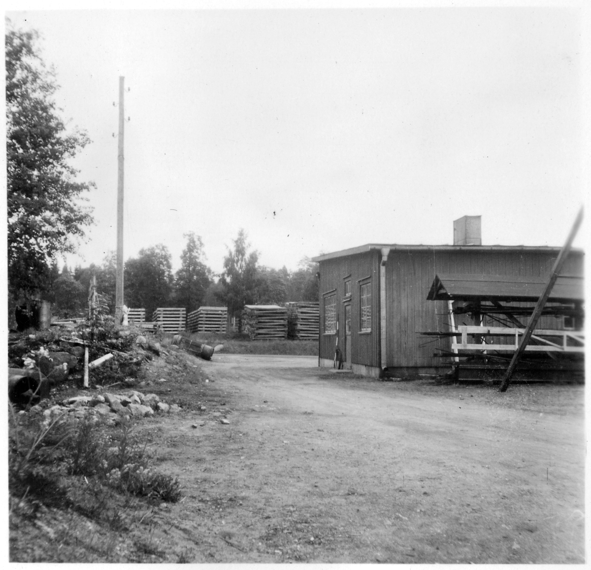 Vägstation T4, Svartå. Garagebyggnad (baksidan). Upplag av diverse material.