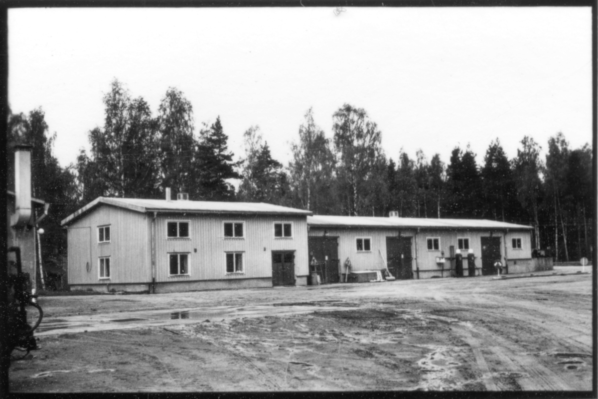 Vägstation W 6, Falun. Kontorsbyggnad, förrådsbyggnad och garagebyggnad. Mot väggen uppställda vägmärken, bland annat "Vägarbete", bensinpumpar (drivmedelspumpar).