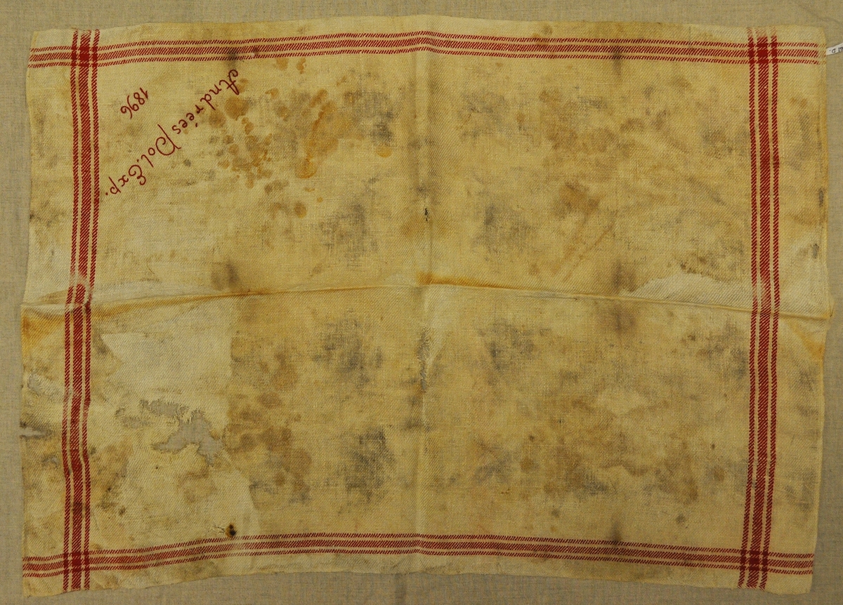 Fyra handdukar i linne med röda bårder. Broderade i stjälkstygn med rött garn, "Andrées Pol. Exp. 1896". Terasiga och fläckiga. Vikta.