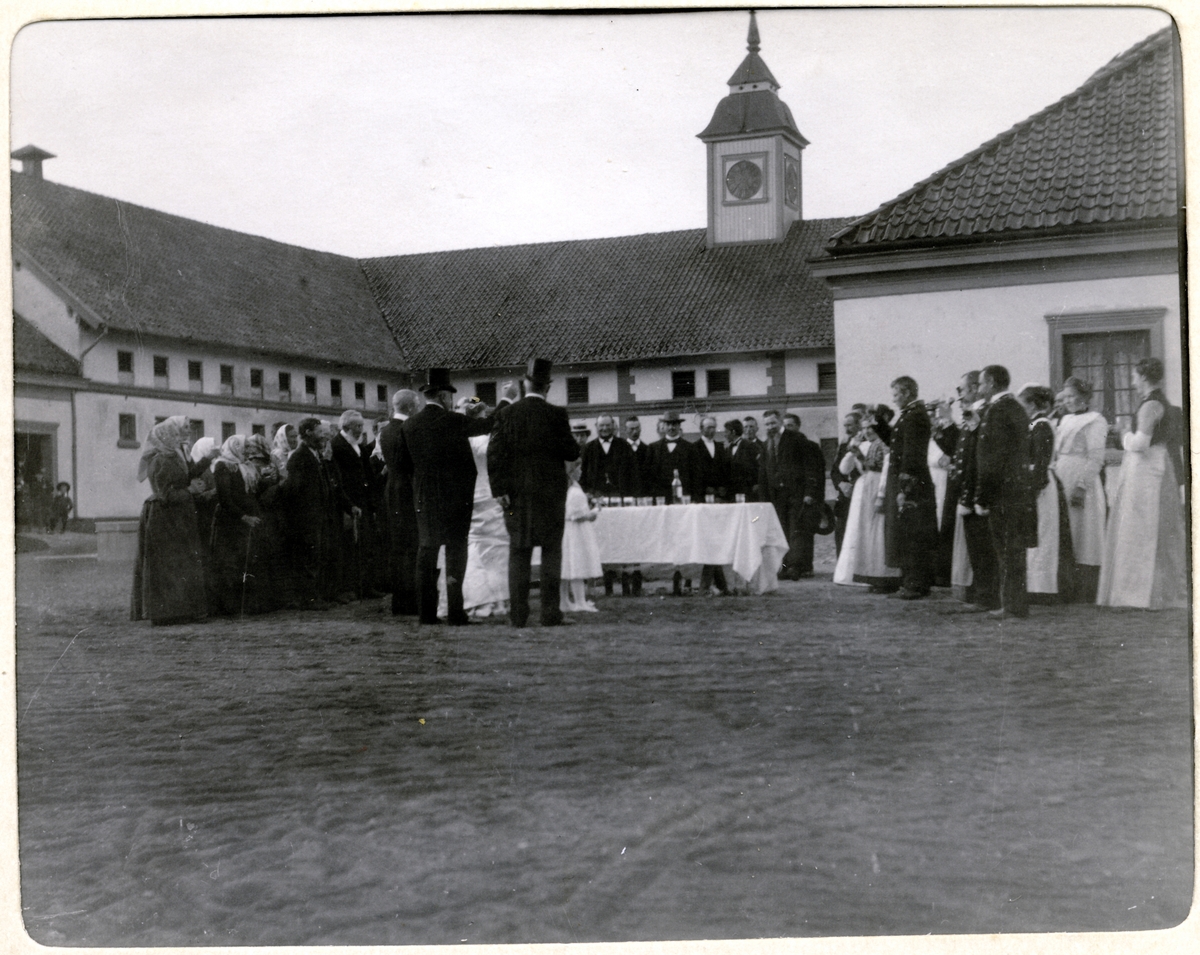 Bryllupsfeiring på Bogstad gård. Brudeparet Nini og Westye Egeberg møter de ansatte på gårdsplassen. Fotografert 17.09.1904.