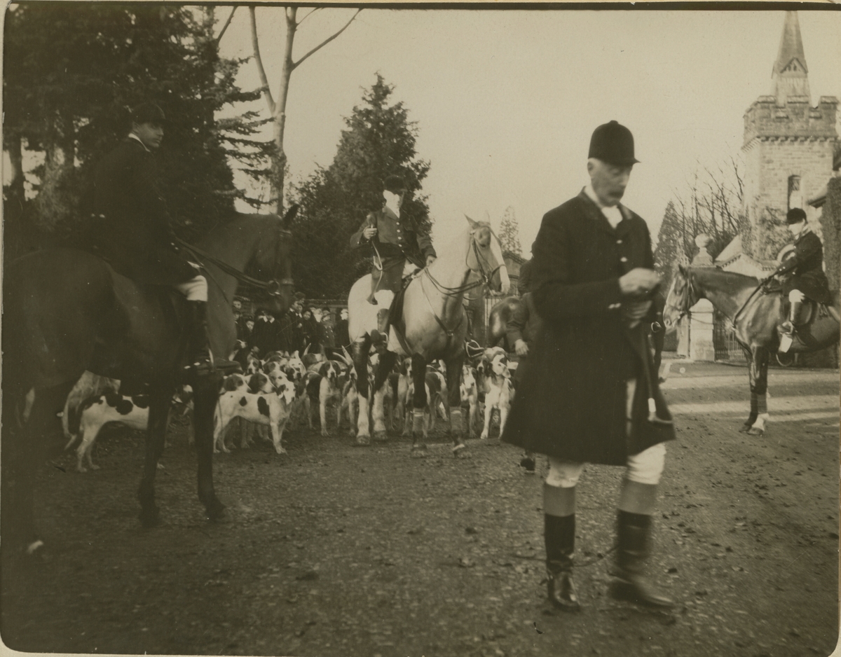 Sir Arthur Herbert fra Coldbrook Park står klar til å starte "The Meet"-jakten I Abergavenny. Tre jegere til hest og et stort kobbel med hunder venter bak. Fotografert 1913.
