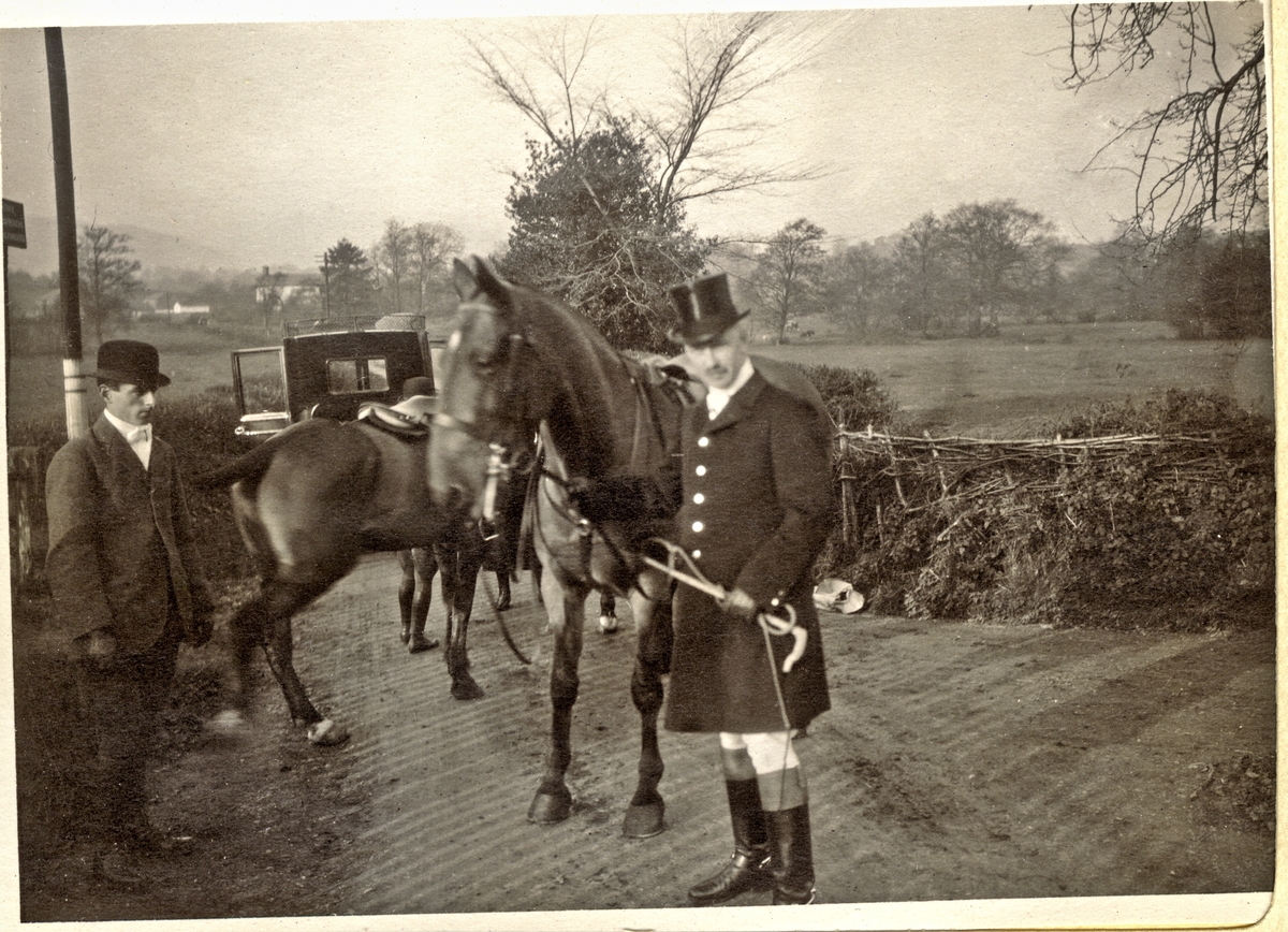 Westye Parr Egeberg deltar i jakten "The Meet" i Abergavenny i Wales.Til venstre antagelig en stallkar med ansvar for hestene. I bakgrunnen en bil med åpen dør. Fotografert 1913.
