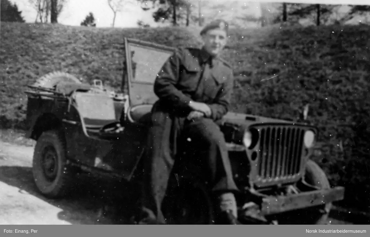 Soldat fotografert foran et militært kjøretøy.
