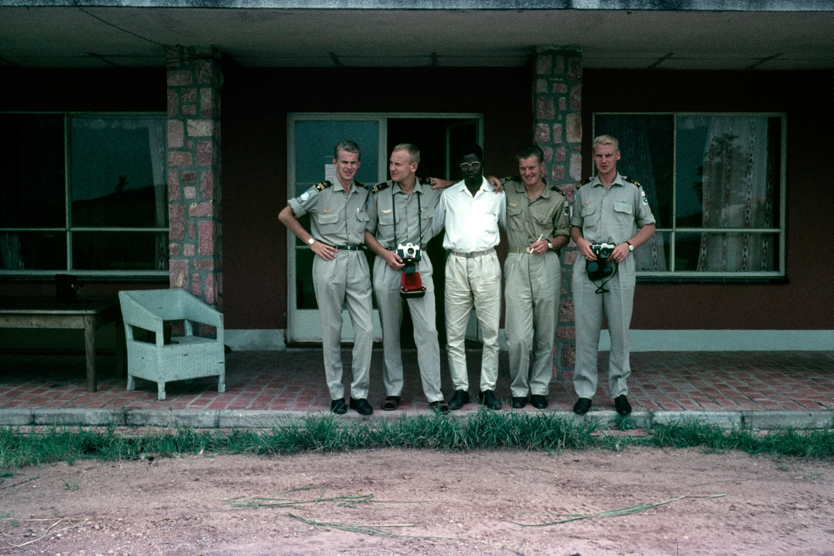 Svenska FN-piloter i Kongo under 1962-1963 tar avsked innan hemfärd. Grupporträtt framför hus.